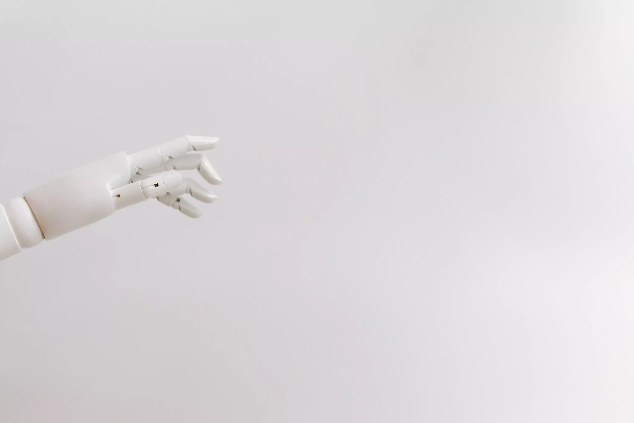 Minimalist image of a robotic hand reaching out on a white background.