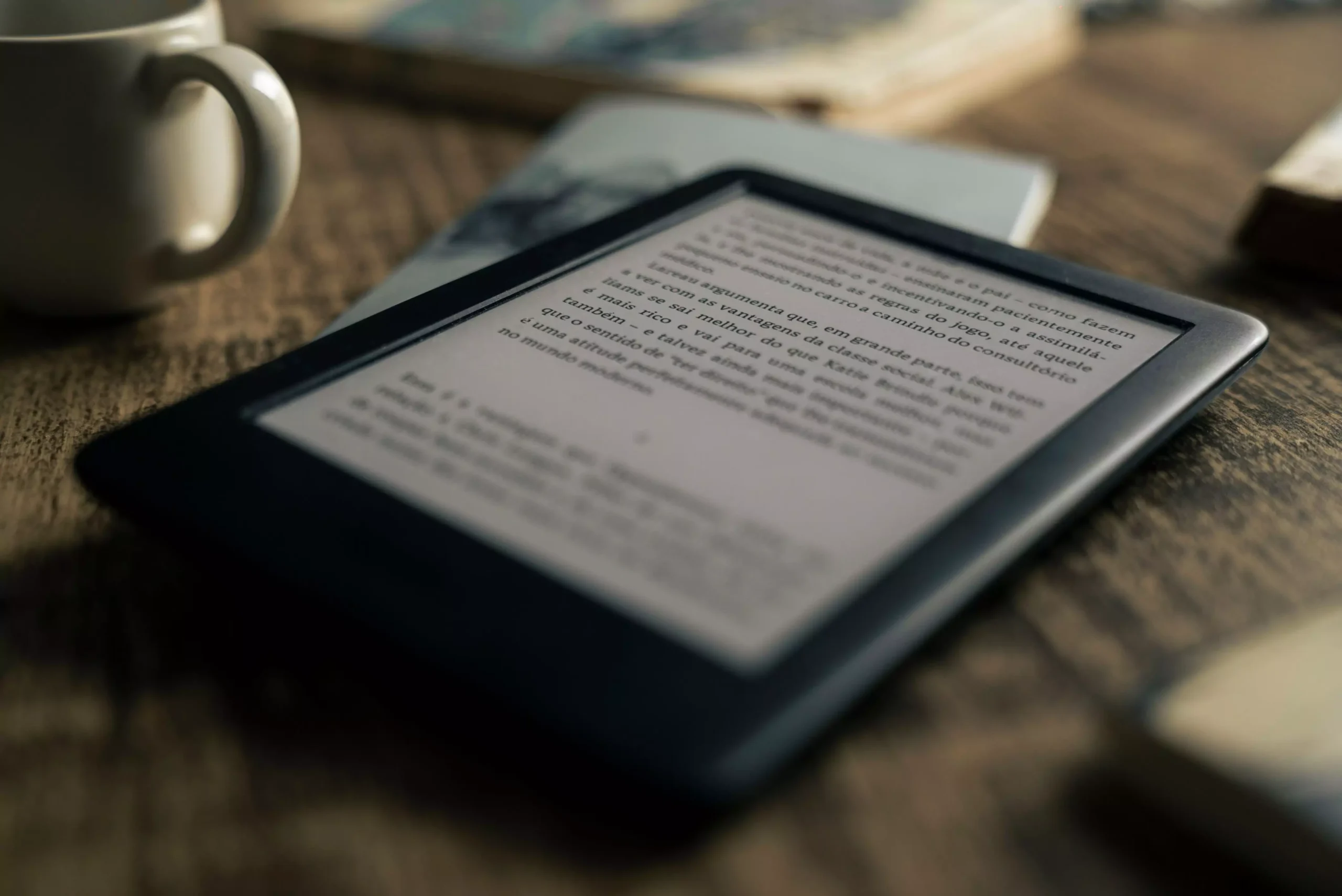 A tablet displaying an ebook on a wooden table next to a coffee cup, ideal for tech and lifestyle themes.
